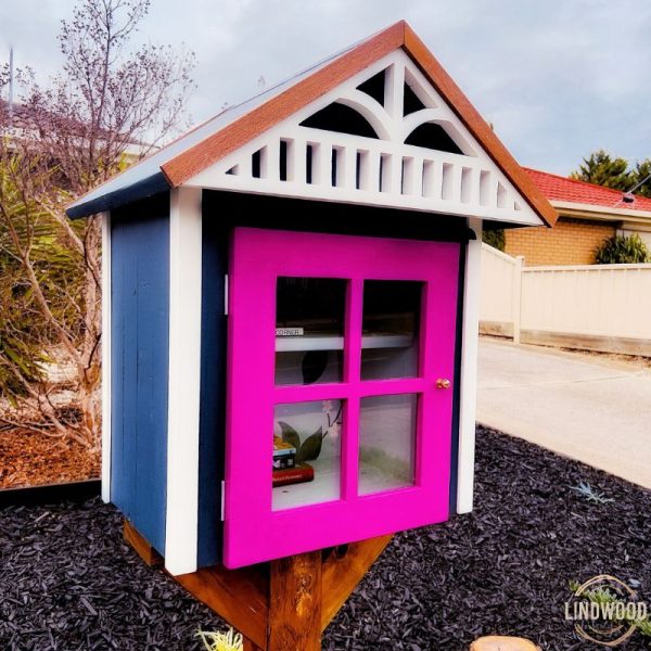 Charming Little Free Library pink door and house-like design invites community book sharing