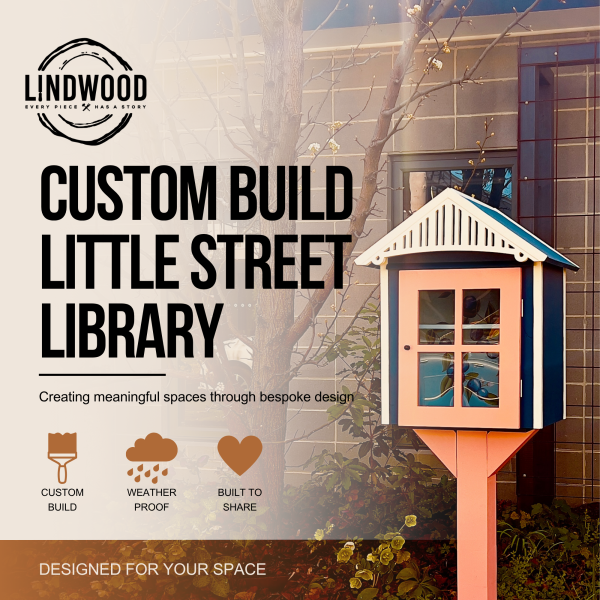 Custom-built little street library with coral door and navy blue roof, displayed in garden setting — Lindwood handcrafted design